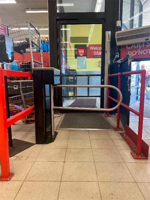 Automatic glass entrance door at a grocery store protected by a Controlled Access loss prevention turnstile.